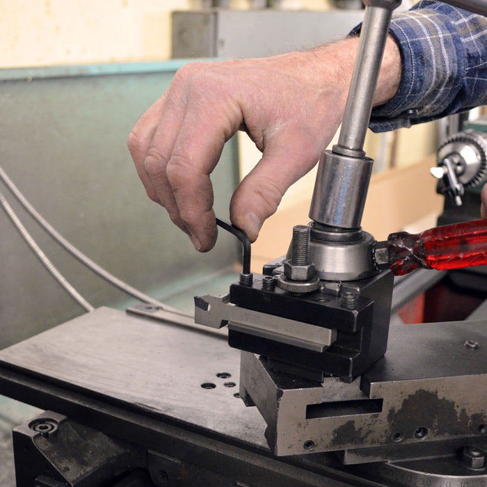 Person operating a machine tool with a focus on the hand and equipment