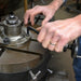 Person operating a metal lathe with hands on a workshop background