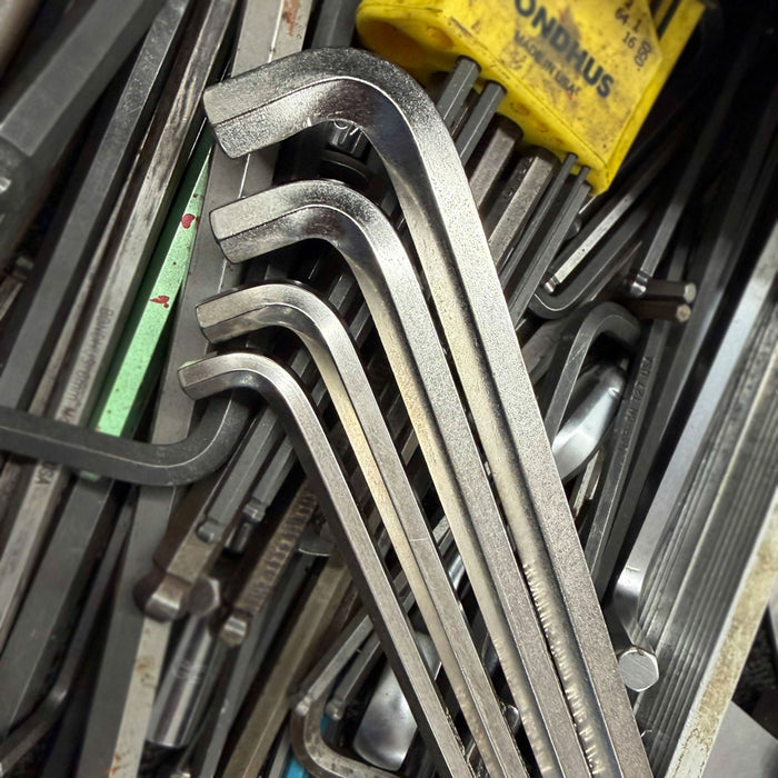 Stack of metal hex keys with a yellow box in the background