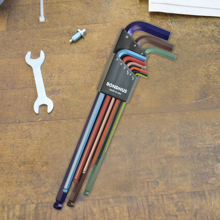 Set of different coloured long hex keys in a Bondhus case on a wooden surface with a wrench and Allen key.