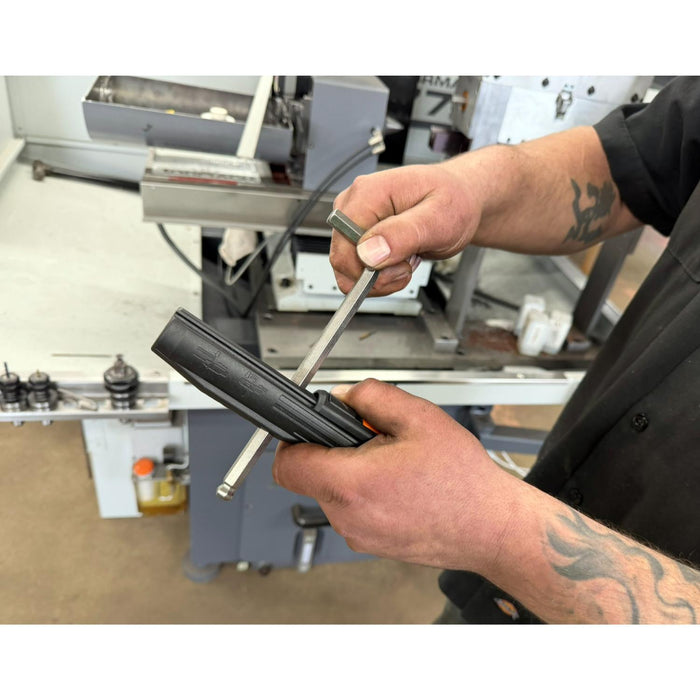 Person using a tool on a piece of equipment in an industrial setting