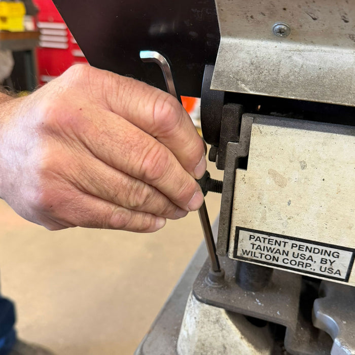 Hand using a tool on a machine with a patent pending label