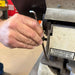 Hand using a tool on a machine with a patent pending label