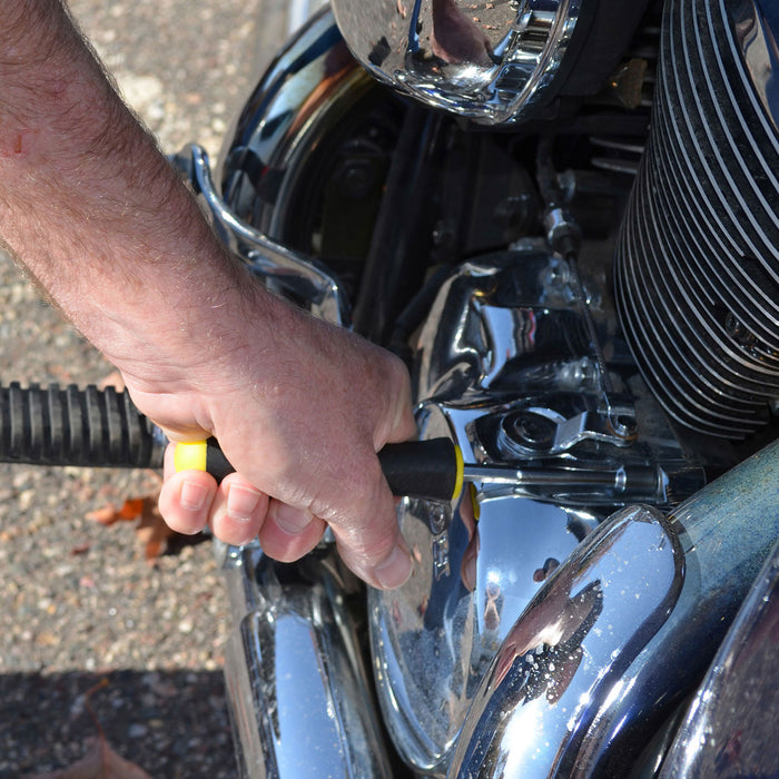 Person using a nut driver to secure chrome fitting on the front of a car