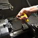 Hand using a yellow t handle tool on a mechanical component