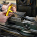 Person using a yellow tool on a metal machine part