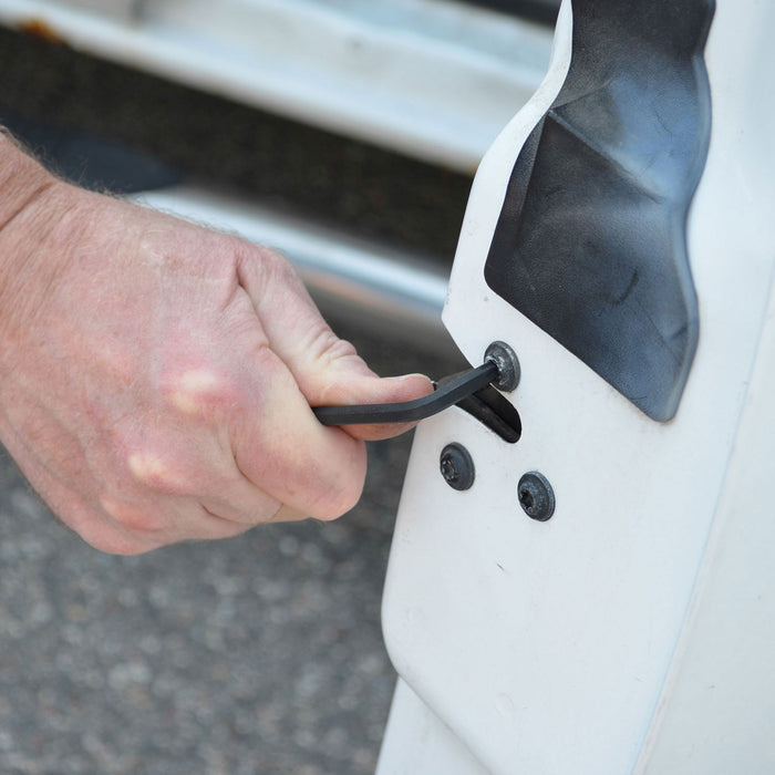 Person using a hex key to tighten bolts on a car door