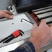 Person using a hex key wrench on a machine part.