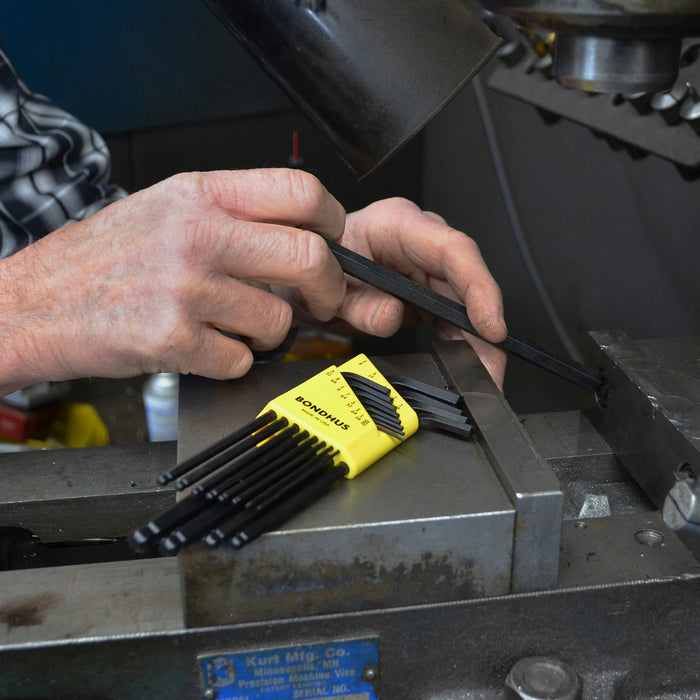 Person using hex keys on a machine part