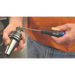 Person wearing an orange T-shirt and jeans using a click set screwdriver to tighten a tool in a workshop