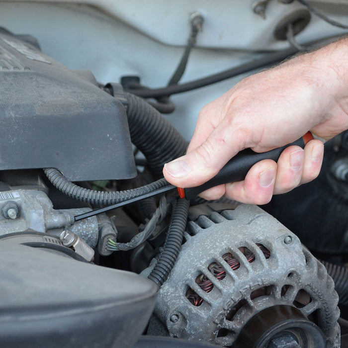 Person working on a car engine with a tool