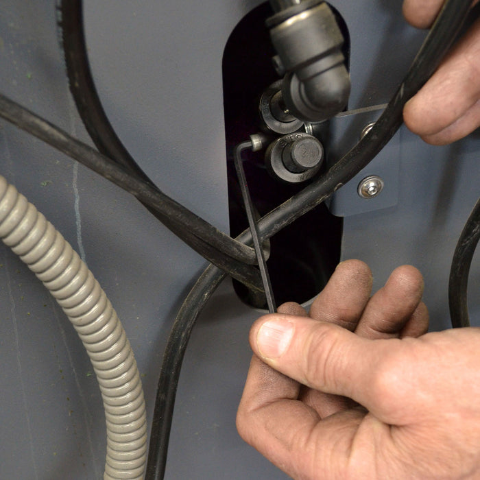 Person tightening metal bracket with small hex key