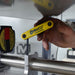 Hand using a Gorilla Grip tool on a metal bar with a blurred background